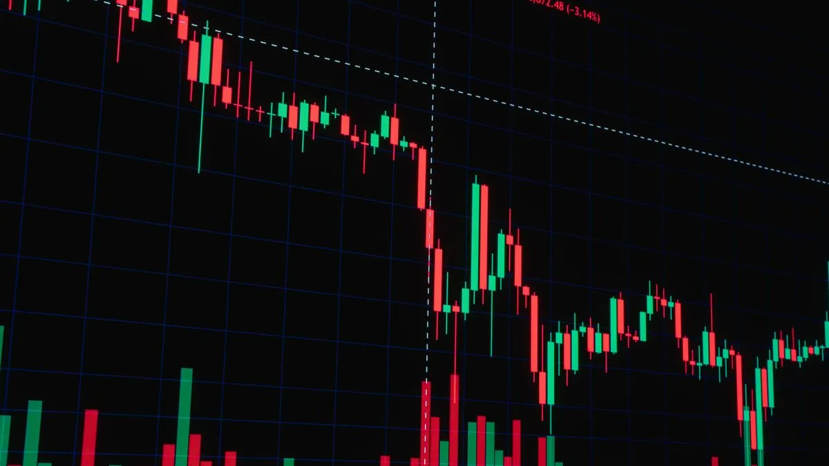 Black-Scholes Model: How Options Are Really Priced A red and green candlestick chart on a dark trading screen falls steeply past a dashed marker line before levelling out.