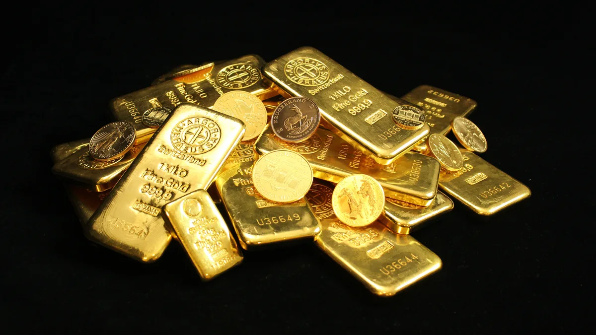 How to Invest in Gold: Physical vs ETFs vs Miners A stack of gold bullion bars and coins in a vault, physical gold you must store and insure